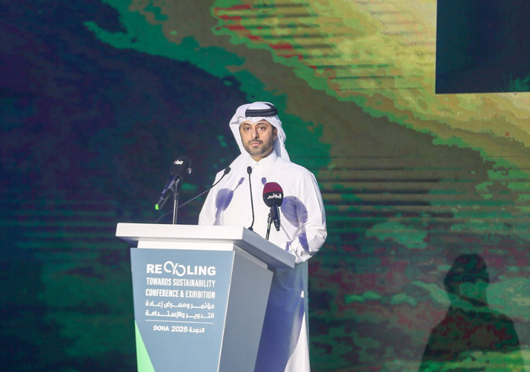Speaker presenting at a Recycling Doha podium